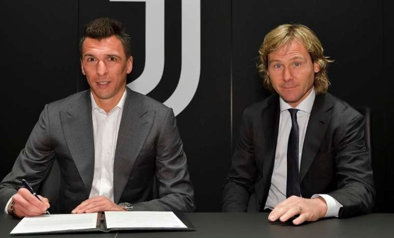 Mandzukic assinou contrato ao lado de Nedved, ídolo e agora diretor da Juventus (Divulgação)