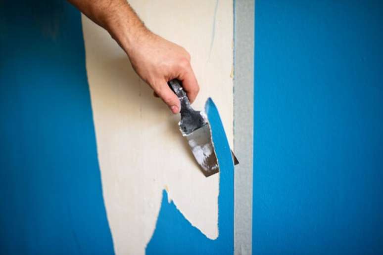 4- Como passar massa corrida na parede depende da remoção de imperfeições, utilize a espátula para tirar a tinta velha e bolhas do produto antigo. Fonte: IStock