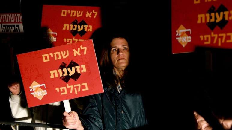 Manifestante anti-Kahanista israelense segura uma placa em hebraico que diz para n&atilde;o colocar o racismo nas urnas