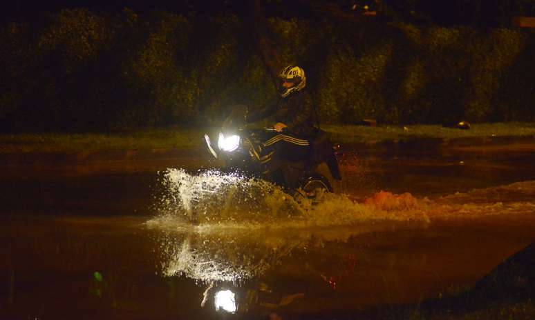 Motociclista anda em rua alagada no Rio de Janeiro após forte chuva atingir a cidade