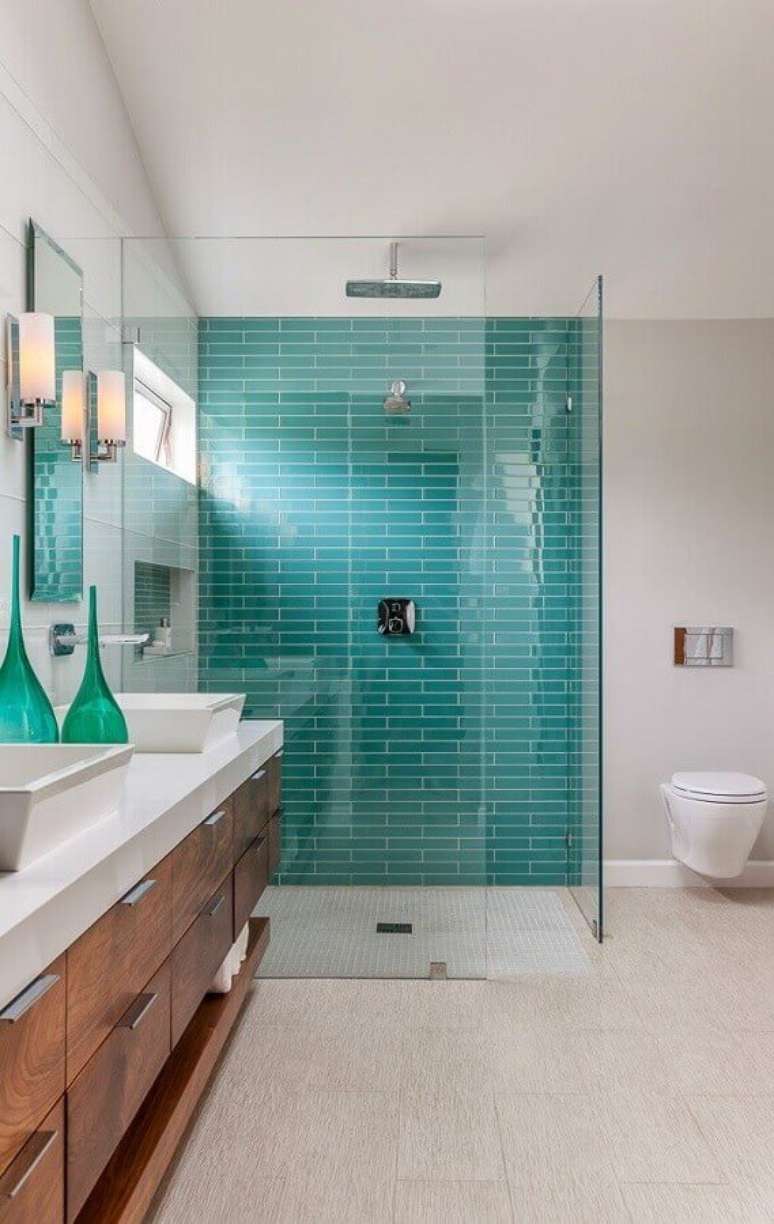 25.. Decoração para banheiro verde água e branco com gabinete de madeira – Foto: The Cavender Diary