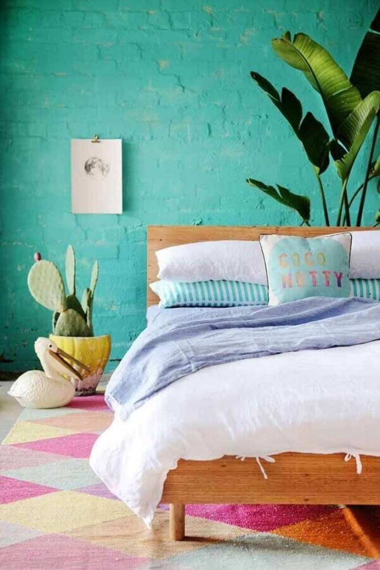 54. Decoração com estilo leve para quarto com tapete colorido, parede verde água e vasos de plantas – Foto: Archzine