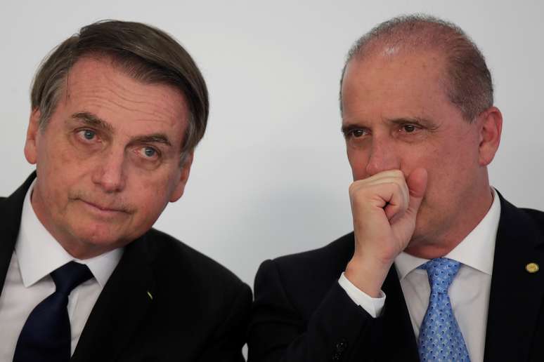 Presidente Jair Bolsonaro conversa com ministro da Casa Civil, Onyx Lorenzoni, durante cerimônia no Palácio do Planalto
25/03/2019 REUTERS/Ueslei Marcelino