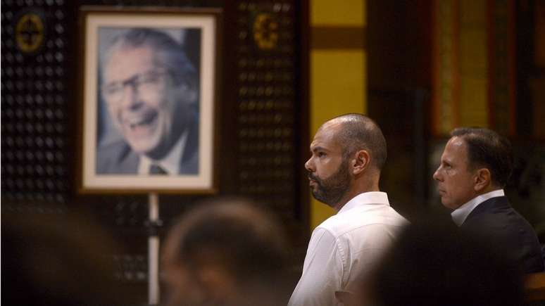 Bruno Covas ao lado de João Doria e foto de Mário Covas ao fundo; prefeito de São Paulo faz reverências frequentes ao avô