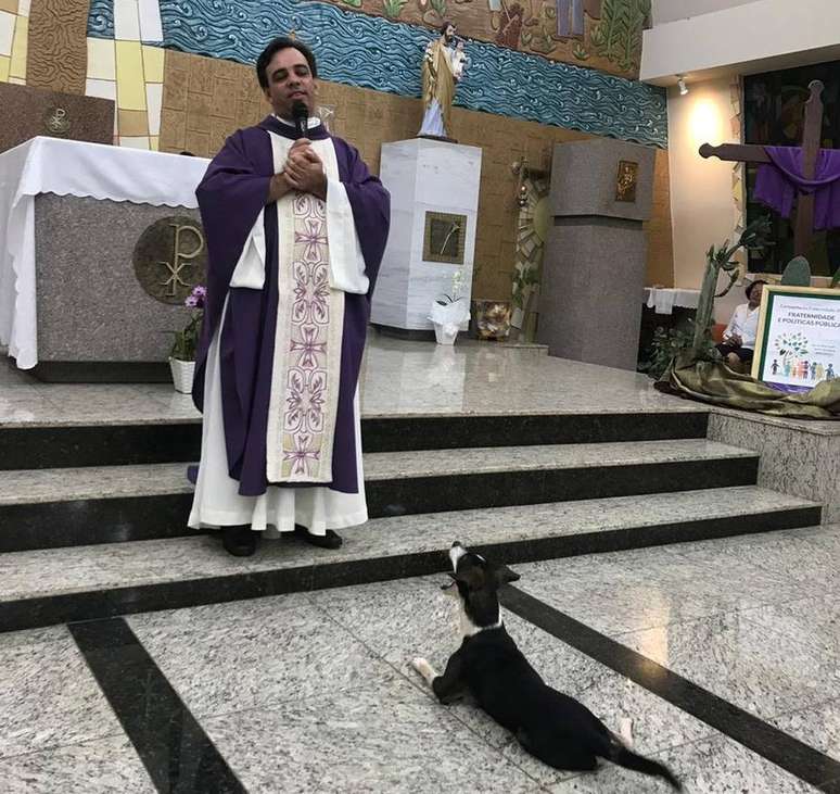 Cão 'Zezinho' acompanha a celebração do padre Ivanaldo e se coloca sobre as patas traseiras na hora da comunhão