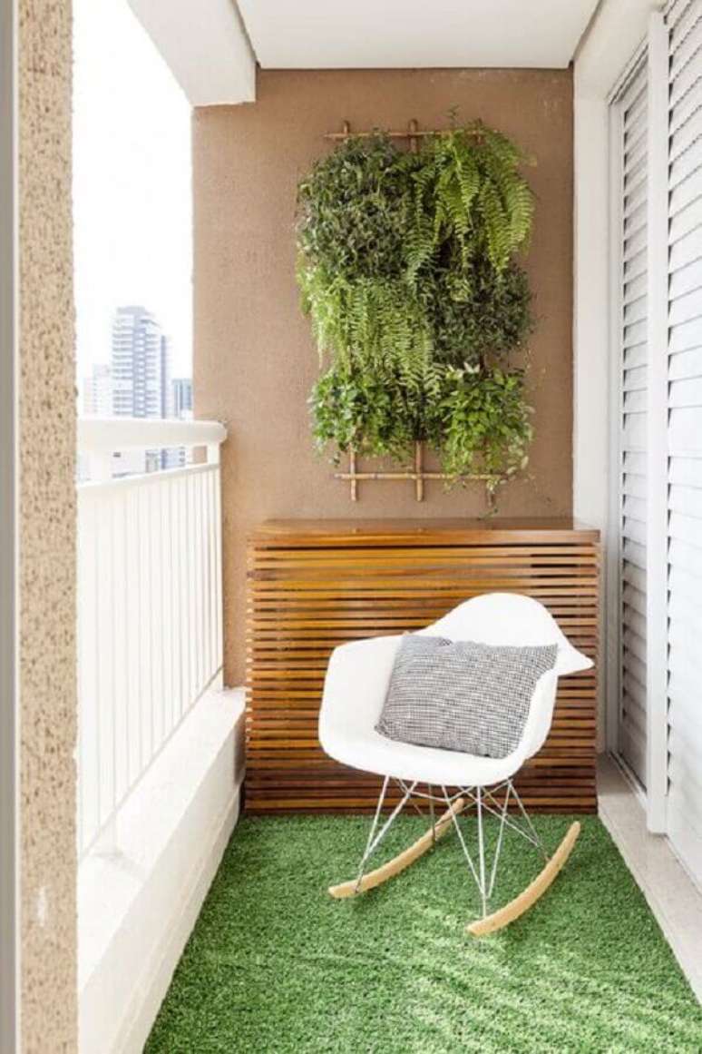 7. Decoração com pequeno jardim vertical e cadeira de balanço para varanda pequena – Foto: Pinosy