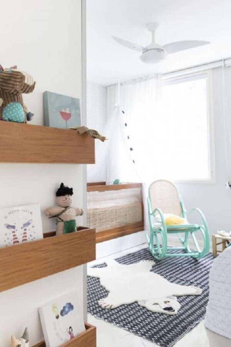 35. Quarto de beb&ecirc; decorado com tapete listrado, ber&ccedil;o de madeira e cadeira de balan&ccedil;o para beb&ecirc; &ndash; Foto: NaToca