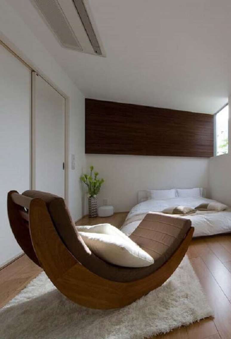 9. Decoração para quarto de casal com tapete felpudo branco e cadeira de balanço moderna de madeira – Foto: Pinosy