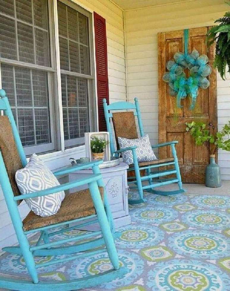 6. Decoração simples com cadeira de balanço para varanda pintada de azul e com piso estampado – Foto: QuitDecor