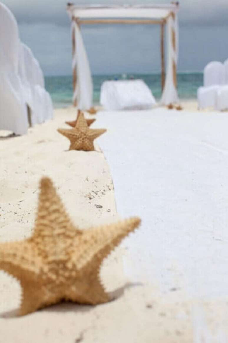 5. Fotos de casamento na praia com decoração com estrelas do mar no caminho para o altar – Foto: Air Freshener