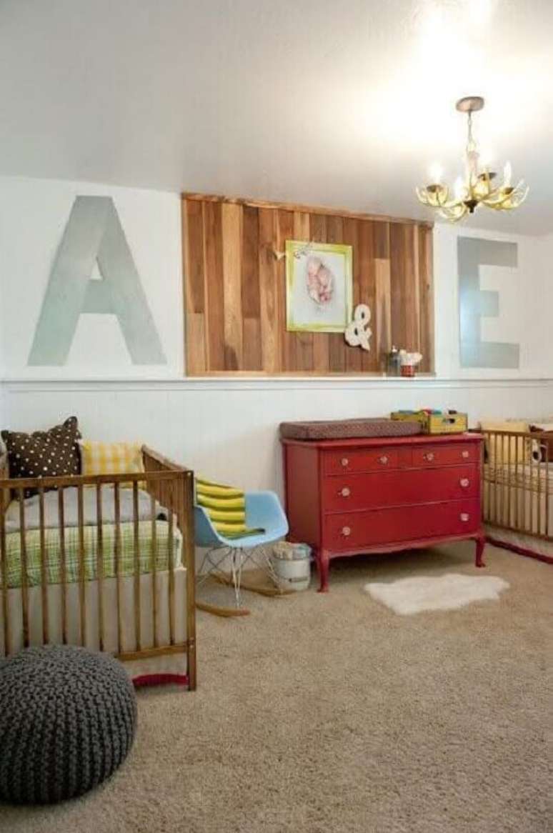 42. Quarto de beb&ecirc; g&ecirc;meos simples decorado com c&ocirc;moda vermelha e painel de madeira &ndash; Foto: Ba&uacute; de Menino
