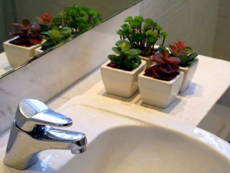 31- Os pequenos vasos com plantas para banheiro decoram a bancada do lavat&oacute;rio. Fonte: Vai com Tudo