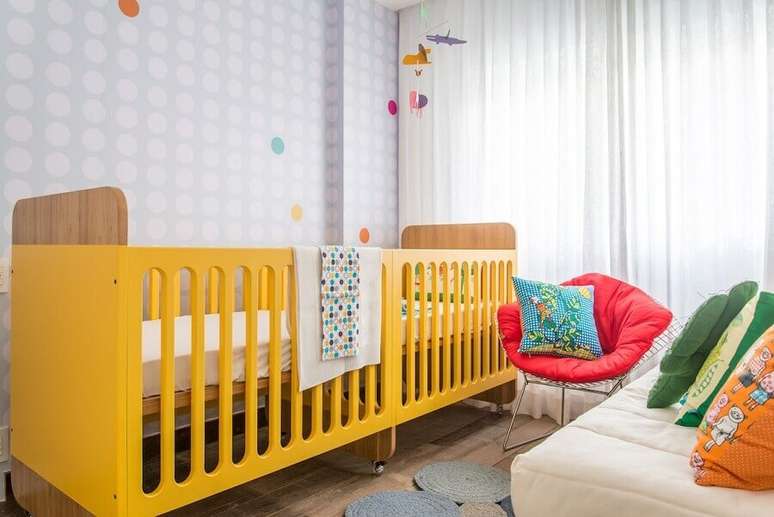 59. Decora&ccedil;&atilde;o alegre para quarto de beb&ecirc; g&ecirc;meos planejado com ber&ccedil;o amarelo e papel de parede cinza com bolinhas brancas &ndash; Foto: Natoca Design