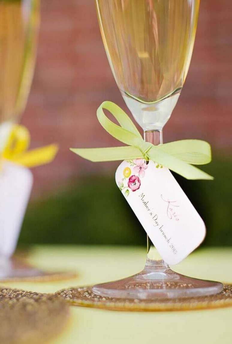 62- Na decora&ccedil;&atilde;o dia das m&atilde;es, as ta&ccedil;as de vinho tem etiquetas e fitas coloridas. Fonte: A Minha Festinha