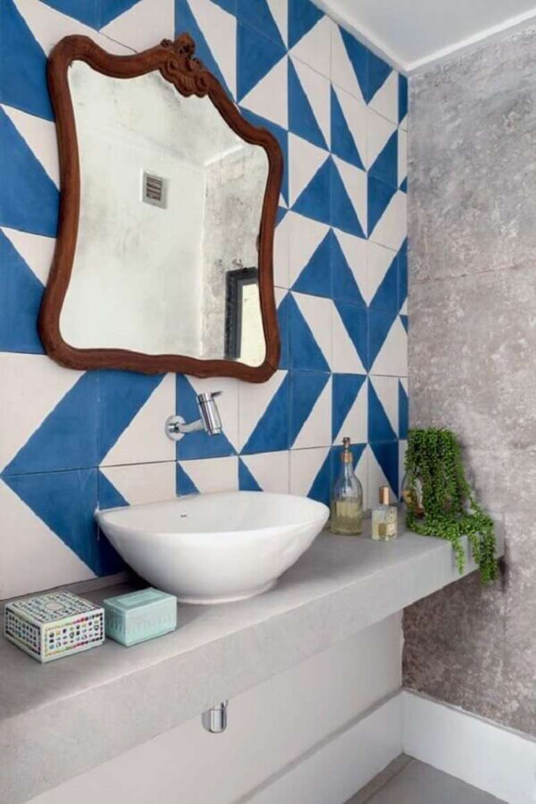 22. Lavabo simples decorado com azulejo azul e branco e espelho com moldura de madeira – Foto: Casa e Festa