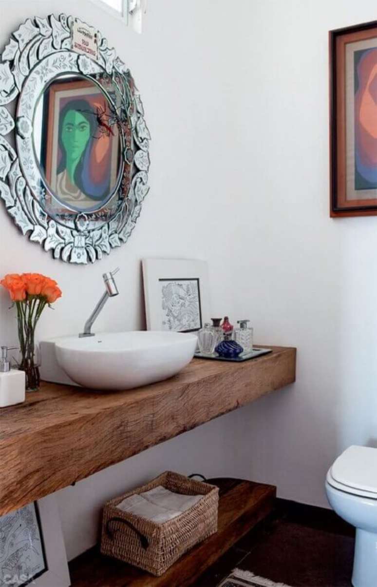 40. Decoração simples com modelo diferente de espelho para lavabo com bancada de madeira – Foto: Casinha Colorida