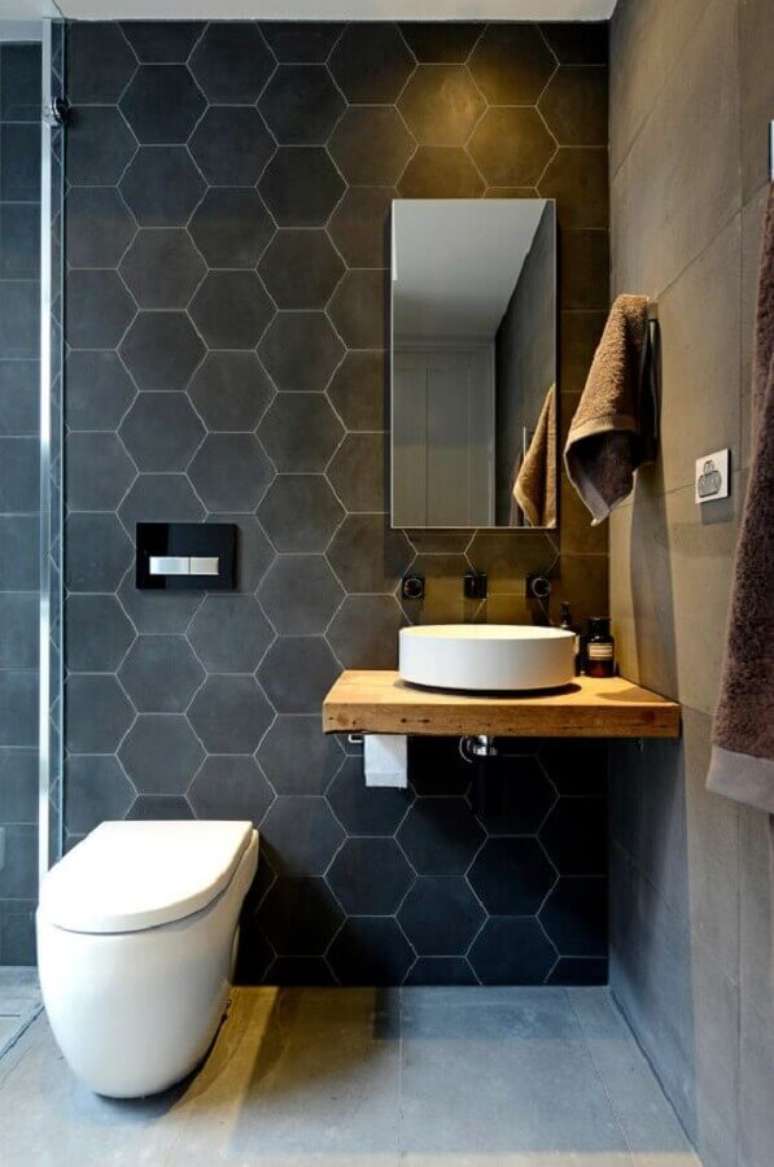 62. Modelo de espelho para lavabo decorado em tons de cinza com pequena bancada de madeira – Foto: Pinterest
