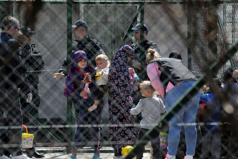 Policiais escoltam mulheres e crianças que são parentes de combatentes do país que lutaram na Síria. 20/4/2019. REUTERS/Laura Hasani - 