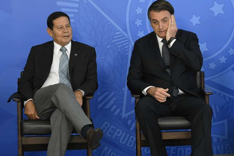 O presidente da República, Jair Bolsonaro (PSL)(d), acompanhado do vice-presidente, general Hamilton Mourão, durante solenidade de assinatura do decreto que revoga o horário de verão realizado no Palácio do Planalto, em Brasília