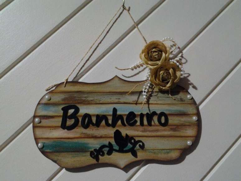 20 &ndash; Enfeite para porta de banheiro feito em madeira. Fonte: Elo7