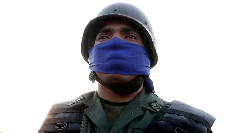 O azul, nos rostos e nos braços, tem sido usado para sinalizar a oposição a Maduro