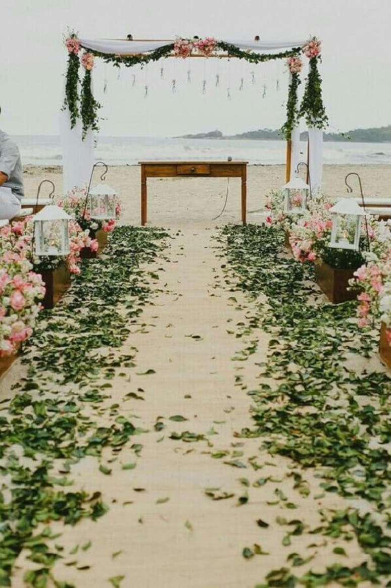 33. Decoração para casamento ao ar livre com arranjo de flores e folhas verdes – Foto: A Noiva de Botas