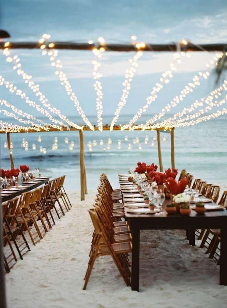 52. Festa de casamento ao ar livre decorada com pisca pisca sobre as mesas – Foto: LM Weddings