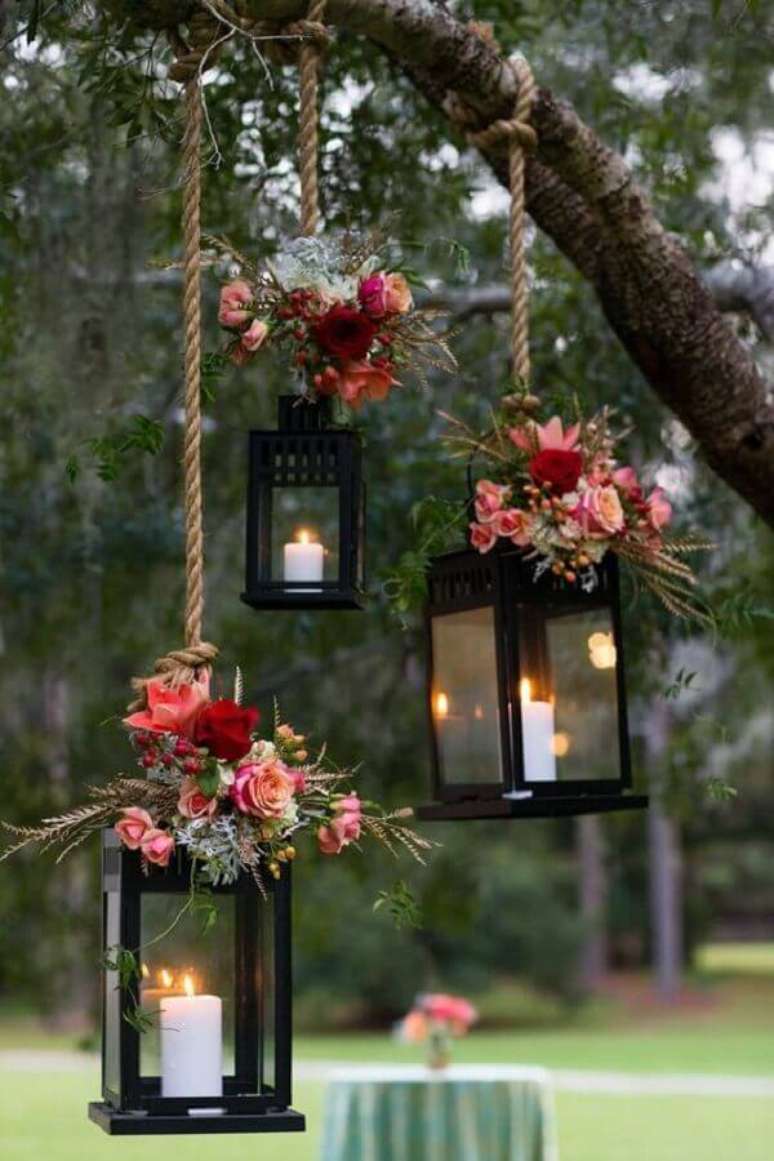 60. As lanternas com velas também pode ser usadas suspensas na decoração de casamento ao ar livre a noite – Foto: The Knot
