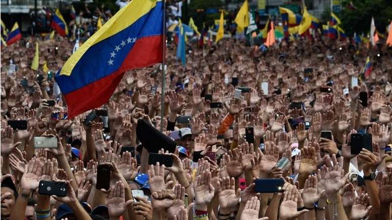 Milhares de pessoas levantaram as mãos como um gesto simbólico de apoio a Juan Guaidó quando ele se declarou presidente
