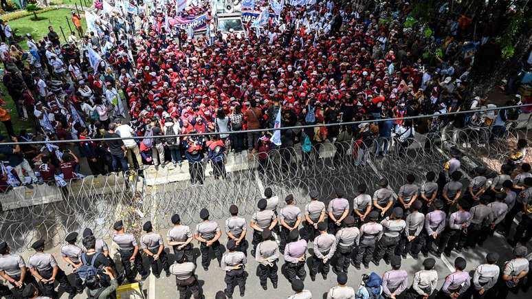 Indonesian activists and workers are blocked by police as they take part in a protest to mark May Day