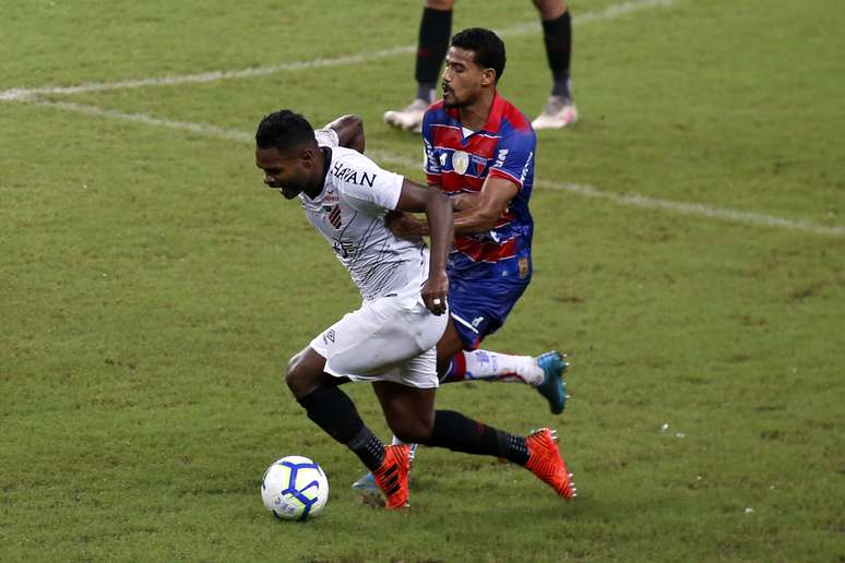 Gabriel Dias, do Fortaleza, disputa lance com Nikão, do Athletico Paranaense, em partida válida pela segunda rodada do Campeonato Brasileiro 2019, na Arena Castelão, na capital cearense, nesta quarta-feira (1º).