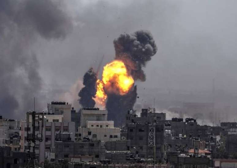 Prédios queimam após bombardeio israelense na Faixa de Gaza