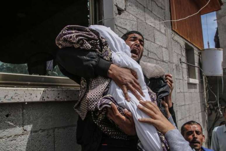 Mulher segura menina de 14 meses morta durante confrontos em Gaza; Israel diz não ter responsabilidade no caso