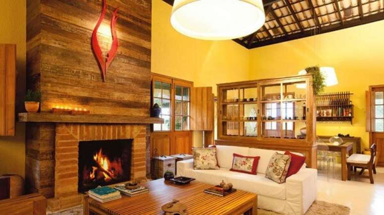 20- A casa r&uacute;stica tem madeira de demoli&ccedil;&atilde;o e tijolo aparente revestindo a lareira. Fonte: Pinterest