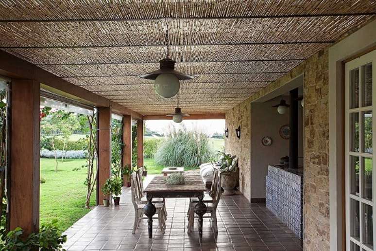 43- Na varanda da casa rústica, os elementos decorativos são: Pedra, bambu e as madeiras dos pilares. Fonte: Casa de Valentina