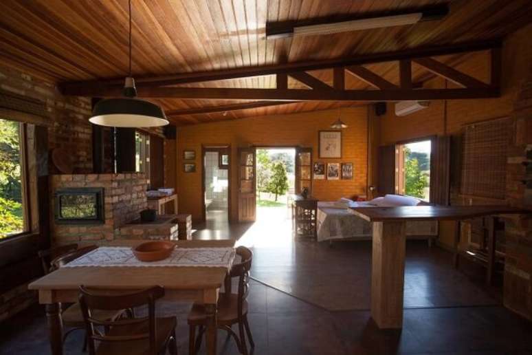 48- A casa rústica em estilo loft tem paredes, forno e fogão à lenha em tijolo aparente. Fonte: Booking