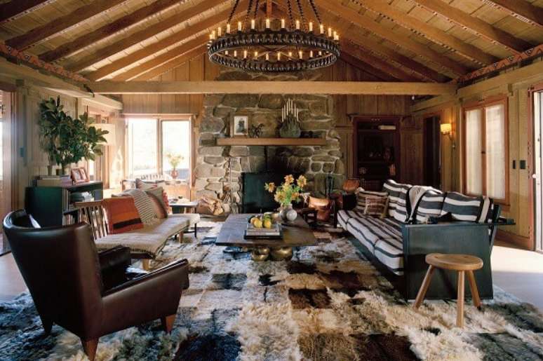 53- A casa de madeira rústica tem lareira de pedra na sala de estar. Fonte: Detalhes do Céu