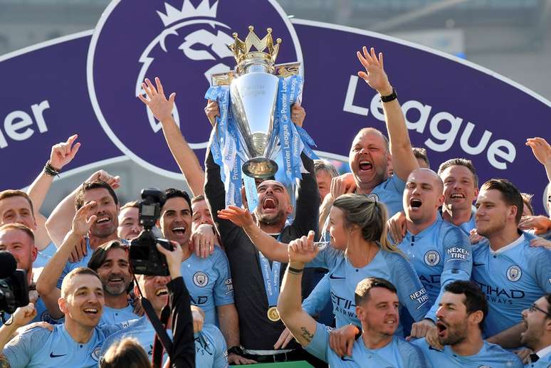 O técnico Pep Guardiola levanta a taça de campeão inglês pelo Manchester City