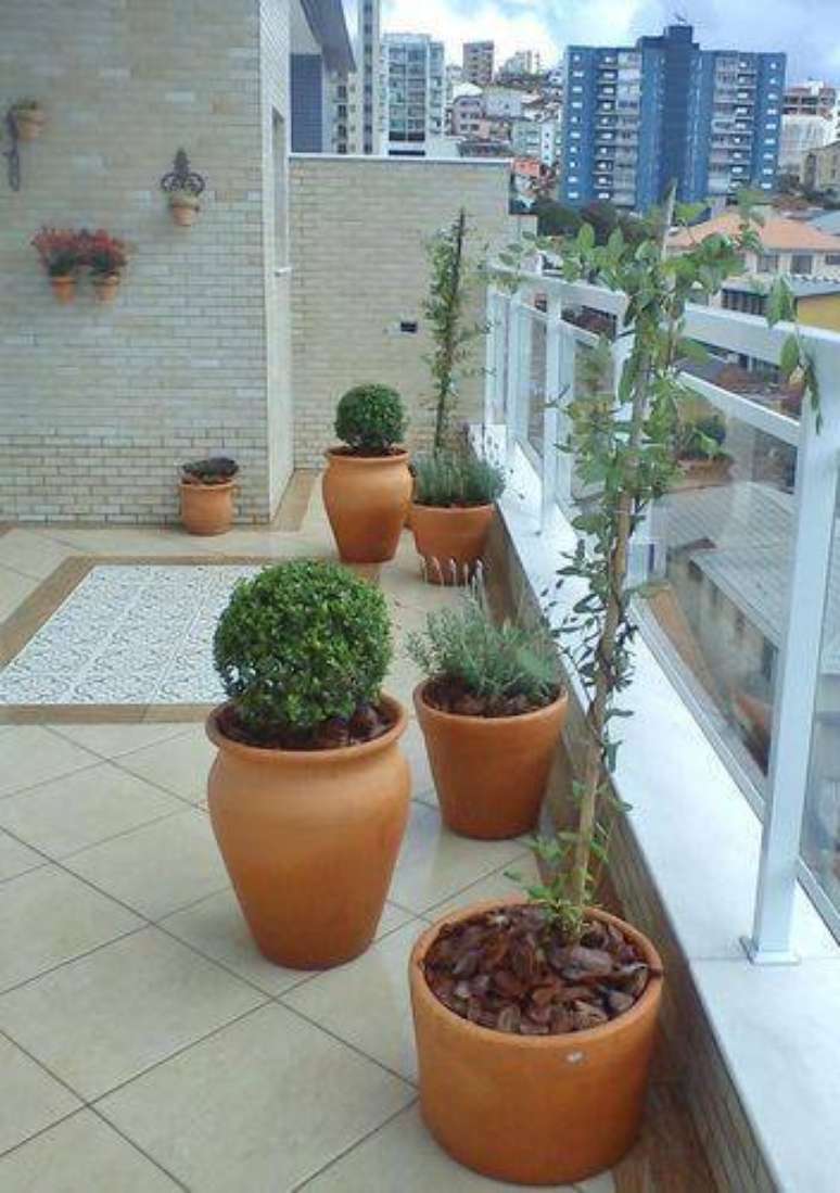 34. Você pode ter um jardim pequeno na varanda com diversos vasos com tamanhos e formas diferentes