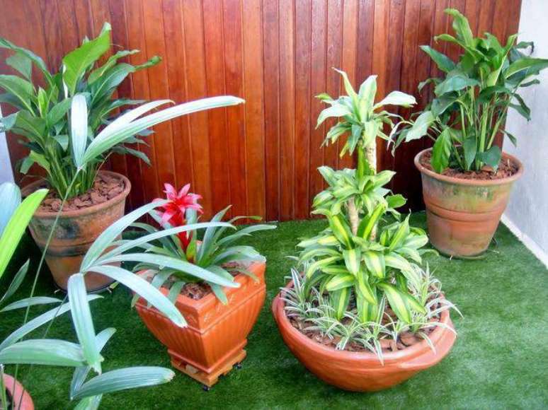 33. Você pode colocar uma grama falsa para preencher o espaço do jardim pequeno na sua casa com vasos