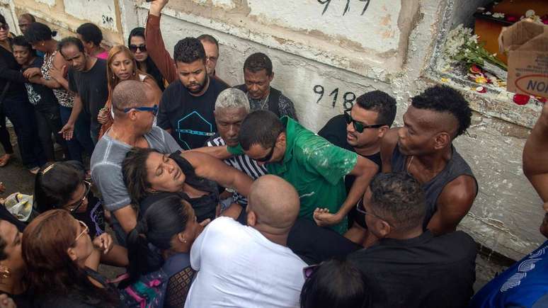 Militars dispararam mais de 200 tiros contra carro conduzido pelo músico Evaldo dos Santos Rosa, sendo que 83 atingiram o veículo. Esposa dele (sendo carregada na foto), o filho de sete anos, o sogro e uma amiga também estavam no veículo