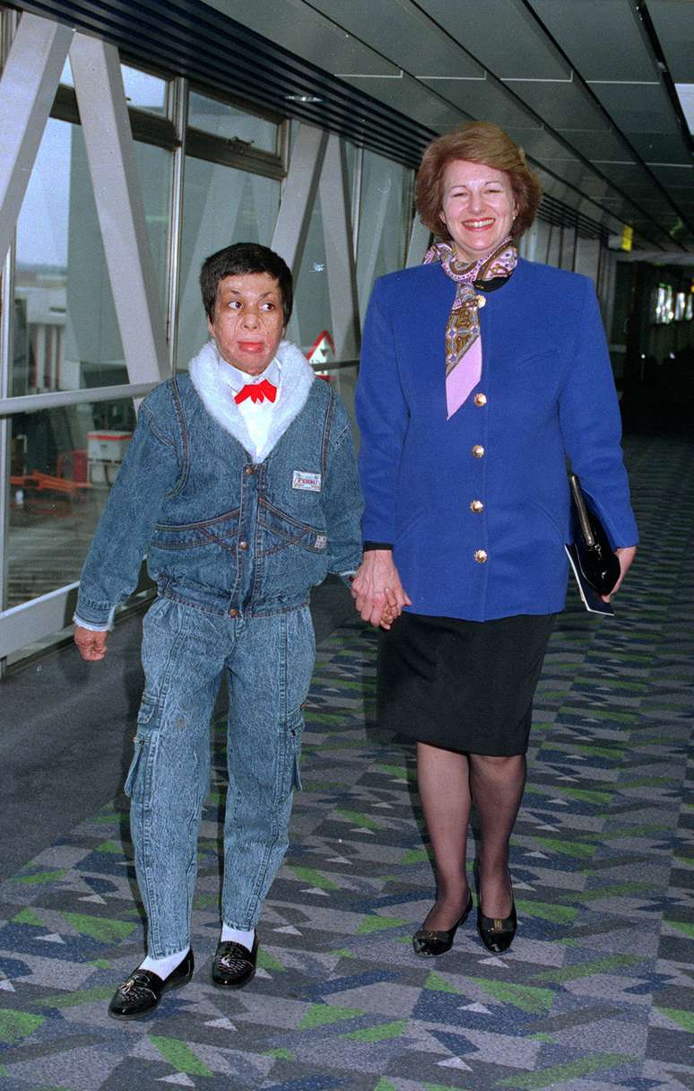 Amar ao chegar no aeroporto de Heathrow com Emma Nicholson; pol&iacute;tica brit&acirc;nica o levou para tratamento no Reino Unido