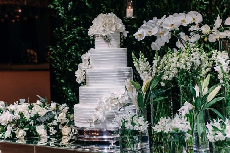 16- A mesa da festa de bodas de prata foi decorada com bolo e flores brancas. Fonte: Flávia Vidal