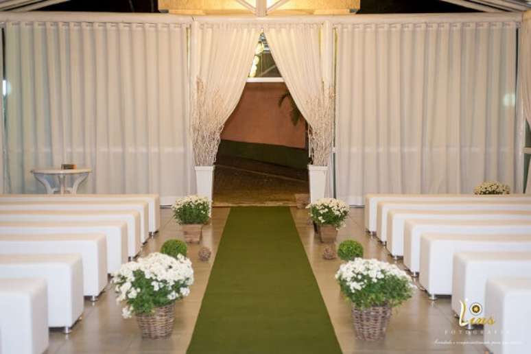 20- Para a cerimônia religiosa de bodas de prata, a decoração foi realizada com bancos e cortinas brancas e caminho com tapete verde. Fonte: Lins Fotografia