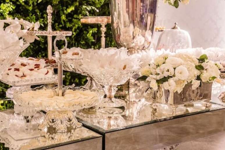 49- A decoração bodas de prata tem cachepot com flores brancas na mesa de doces. Fonte: Vestida de Noiva