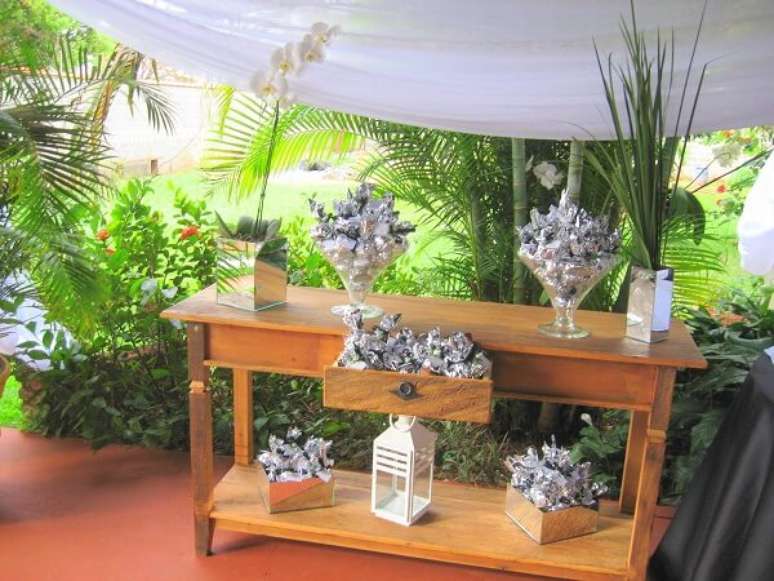 51- Na decoração bodas de prata, o aparador serve de apoio para as lembrancinhas embrulhadas em papel prateado. Fonte: Portal das Noivas