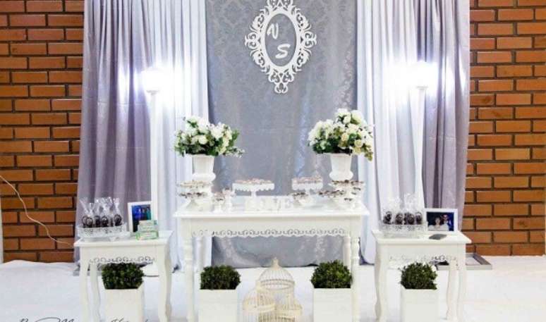 54- Na decoração bodas de prata, o painel da parede atrás da mesa tem as iniciais dos nomes do casal. Fonte: Mari Festas