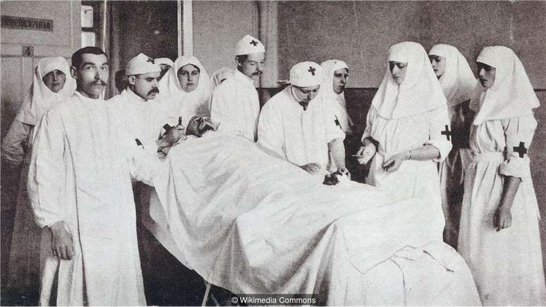 Gedroits, auxiliada pela Imperatriz Alexandra e pelas Grã-duquesas Olga e Tatiana, opera um paciente (Crédito: Wikimedia Commons)