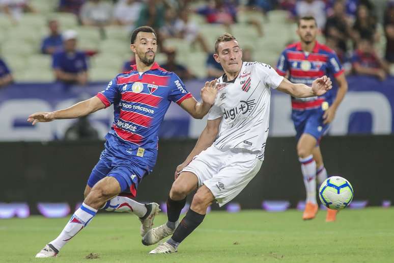 Roger Carvalho (e), do Fortaleza, disputa lance com Marco Ruben, do Athletico Paranaense, em partida válida pelas oitavas de final da Copa do Brasil 2019, na Arena Castelão, em Fortaleza, nesta quinta-feira (16).