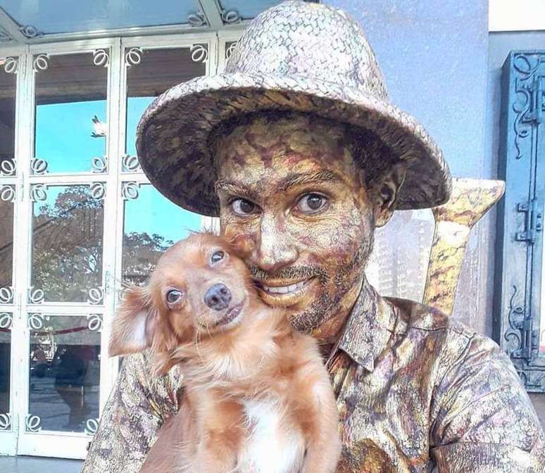 Yorge Luís Ruiz, artista de rua e imigrante venezuelano que trabalha como estátua viva em Fortaleza, Ceará, com sua cachorrinha.